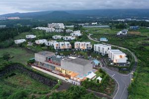 een luchtzicht op een stad met gebouwen en een weg bij Velum Resort in Seogwipo