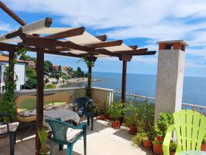 um pátio com uma mesa e cadeiras e o oceano em Guest House Neli em Nessebar