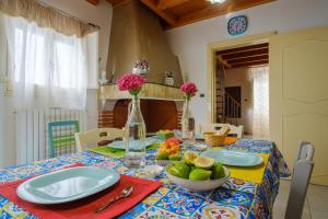 einen Tisch mit Tellern und eine Schale Obst darauf in der Unterkunft Casa Ta Nonna in Supersano