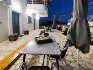 a table and chairs on a patio at night at Dina's Apartment in Himare