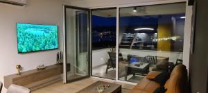 - un salon avec un canapé et une grande fenêtre dans l'établissement Penthouse Apartman Marčelina in Trogir, à Trogir