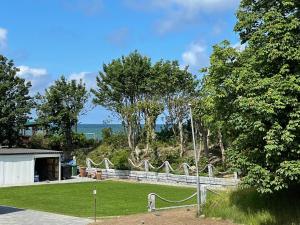 a park with a fence and trees and the ocean at Apartamenty Przy Wydmach in Chłopy