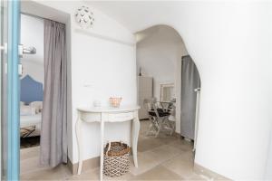 um quarto branco com uma mesa e uma cama em Dimore del TEMPO PERS0 Terrae Globus em Ostuni