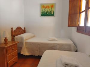 una camera con due letti, un comò e una finestra di Sol y Mar a Isla Cristina
