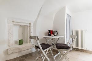 uma mesa e duas cadeiras num quarto com um espelho em Dimore del TEMPO PERS0 Terrae Globus em Ostuni
