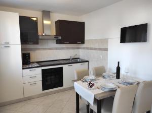 a kitchen with a table and chairs and a kitchen with a counter at Apartman Poldrugovac in Labin