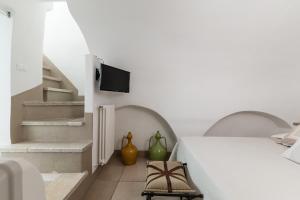 a bedroom with a bed and a tv on the wall at Dimore del TEMPO PERS0 Terrae Globus in Ostuni