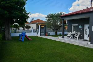 a yard with a playground and a house at VILLA KOSTAS in Chaïdeftón