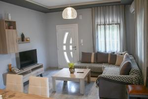 a living room with a couch and a table at VILLA KOSTAS in Chaïdeftón