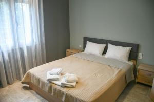 a bedroom with a bed with two towels on it at VILLA KOSTAS in Chaïdeftón