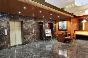 a lobby with a marble wall and a desk at Comfort Inn Insys in Bangalore