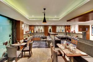 Un restaurante con mesas y sillas de madera y un bar. en Comfort Inn Insys, en Bangalore