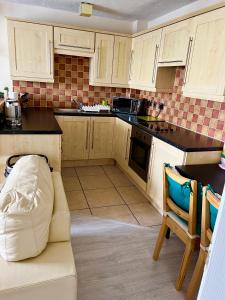 a kitchen with wooden cabinets and a couch in it at Campbell Apartment in Cardiff