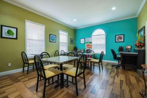 une salle à manger avec des murs verts, une table et des chaises dans l'établissement Quality Inn, à DeRidder