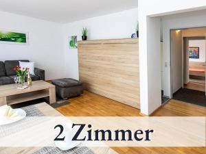 una sala de estar con una gran puerta corredera de madera en Große moderne Ferienwohnung in bester Bodenseelage l 1 Minute zum Bodensee l 2 Zimmer l Vollausgestattete Küche l Sonnenbalkon l WLAN l Willkommen im Apartment Güttingen, en Radolfzell am Bodensee