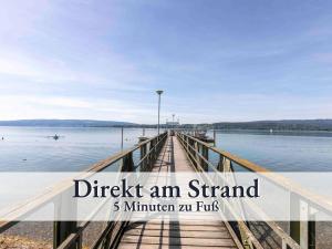 un muelle en el agua con las palabras revisa un stand min min min min min en Große moderne Ferienwohnung in bester Bodenseelage l 1 Minute zum Bodensee l 2 Zimmer l Vollausgestattete Küche l Sonnenbalkon l WLAN l Willkommen im Apartment Güttingen, en Radolfzell am Bodensee