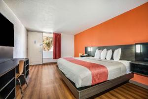 a hotel room with a bed with an orange wall at Studio 6 Florence, SC in Florence