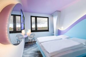 Una habitación de hotel con dos camas y un espejo. en Prize by Radisson, Rostock City, en Rostock