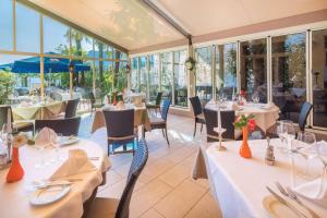 un restaurante con mesas, sillas y ventanas en Best Western Hotel Bellevue au Lac en Lugano