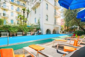 une piscine avec des chaises et un bâtiment dans l'établissement Best Western Hotel Bellevue au Lac, à Lugano