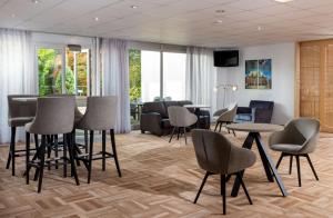 una sala de espera con mesas, sillas y ventanas en Best Western Hotel Achim Bremen en Bremen