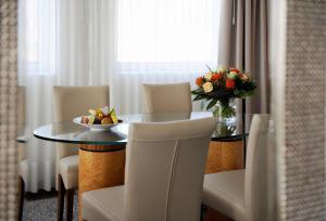 a table with a bowl of fruit and a vase of flowers at Best Western Premier Hotel Beaulac in Neuchâtel