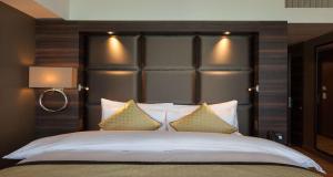 a bedroom with a large bed with a large headboard at Best Western Premier Hotel Beaulac in Neuchâtel