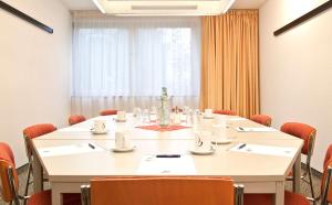 una sala conferenze con un grande tavolo bianco e sedie di Best Western Hotel Achim Bremen a Brema
