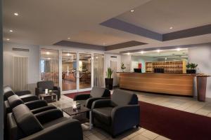 多特蒙德的住宿－多特蒙德機場貝斯特韋斯特酒店，一间设有真皮座椅的等候室和一个大堂