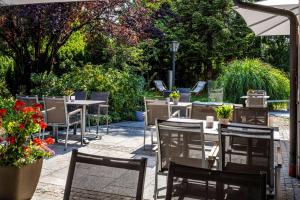 an outdoor restaurant with tables and chairs and flowers at Best Western Plus Hotel Erb in Parsdorf