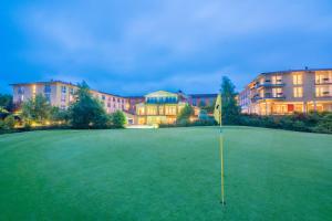 un campo de golf con una bandera en medio de un green en Best Western Premier Castanea Resort Hotel, en Lüneburg