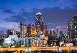 uma vista para o horizonte da cidade à noite em SureStay Plus by Best Western Sukhumvit 2 em Bangkok