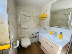 a white bathroom with a sink and a toilet at Allgäuerferienwohnung in Sulzberg