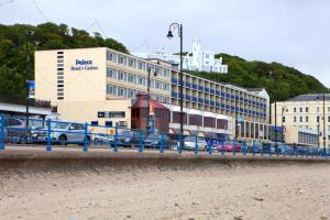 a building with cars parked in front of a train at Best Western Palace Hotel & Casino in Douglas