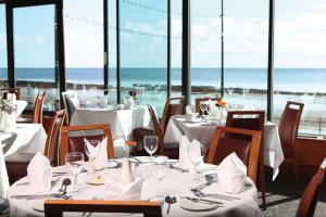 a restaurant with tables and chairs with a view of the ocean at Best Western Palace Hotel & Casino in Douglas