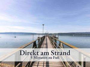 un molo sull'acqua con sovrapposizione di testo verifica un banco di prova min min. di Großzügige Ferienwohnung mit zwei Sonnenbalkonen in bester Bodenseelage l 1 Minute zum Bodensee l 2 Zimmer l Vollausgestattete Küche l Free-WLAN l Willkommen im Apartment Markelfingen a Radolfzell am Bodensee