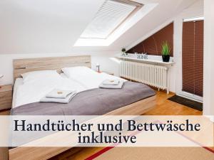 1 dormitorio con 1 cama con 2 toallas en Großzügige Ferienwohnung mit zwei Sonnenbalkonen in bester Bodenseelage l 1 Minute zum Bodensee l 2 Zimmer l Vollausgestattete Küche l Free-WLAN l Willkommen im Apartment Markelfingen, en Radolfzell am Bodensee