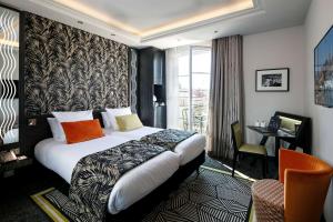 a hotel room with a large bed and a desk at BW Premier Collection Mondial in Cannes