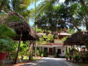 a courtyard of a house with palm trees at Tattwamasi Ayuryoga with Breakfast and Yoga in Varkala