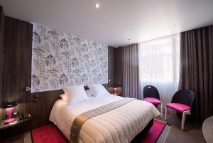 a hotel room with a bed and two pink chairs at Best Western Premier Le Patio des Artistes Wellness Jacuzzi in Cannes