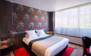 a hotel room with a bed and a window at Best Western Premier Le Patio des Artistes Wellness Jacuzzi in Cannes