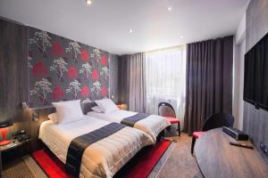 a hotel room with a bed and a table at Best Western Premier Le Patio des Artistes Wellness Jacuzzi in Cannes