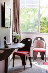 a room with a table and a chair and a window at Best Western Premier Le Patio des Artistes Wellness Jacuzzi in Cannes