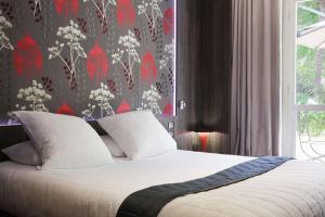 a bedroom with a bed with a red and white wallpaper at Best Western Premier Le Patio des Artistes Wellness Jacuzzi in Cannes