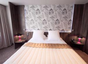 a bedroom with a large bed with two lamps at Best Western Premier Le Patio des Artistes Wellness Jacuzzi in Cannes