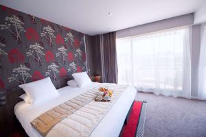 a bedroom with a large bed with two teddy bears on it at Best Western Premier Le Patio des Artistes Wellness Jacuzzi in Cannes