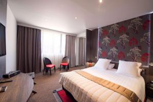 a hotel room with a bed and a table at Best Western Premier Le Patio des Artistes Wellness Jacuzzi in Cannes