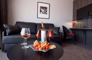 a table with a bottle of wine and a glass at Best Western Premier Le Patio des Artistes Wellness Jacuzzi in Cannes