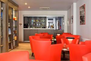 un restaurante con sillas naranjas y un bar en Best Western Premier Le Patio des Artistes Wellness Jacuzzi en Cannes