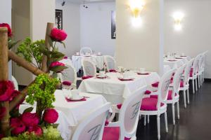 a room with white tables and pink chairs and roses at Best Western Premier Le Patio des Artistes Wellness Jacuzzi in Cannes